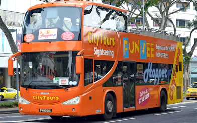 Open-top orange FunVee bus on Singapore city tour route.