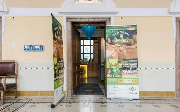 Hallway entrance to Szechenyi Spa with beer spa promotional banners.