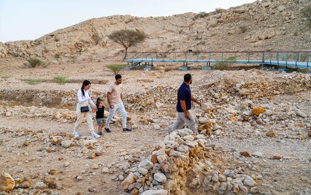 Visitors exploring ancient ruins at Mleiha Archaeology Centre on the Sounds of the Past Tour.