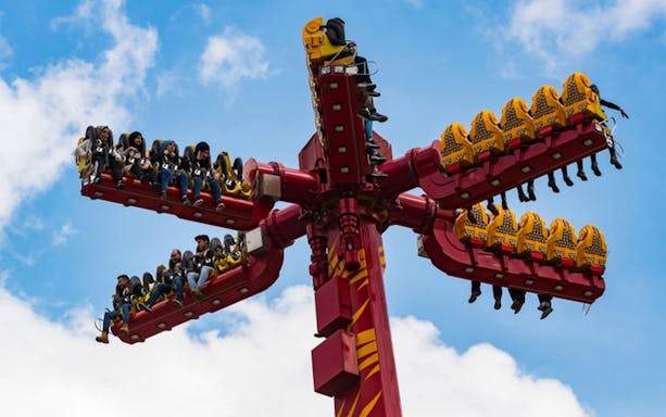 Thrill ride at Vialand Theme Park with people enjoying the experience.