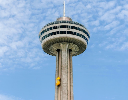 Niagara Falls view of Skylon Tower observation deck, Ontario, with cityscape and river in the background.