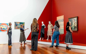 Visitors observing art and fashion exhibits at the National Gallery of Victoria during the Best of NGV Experiences Tour.