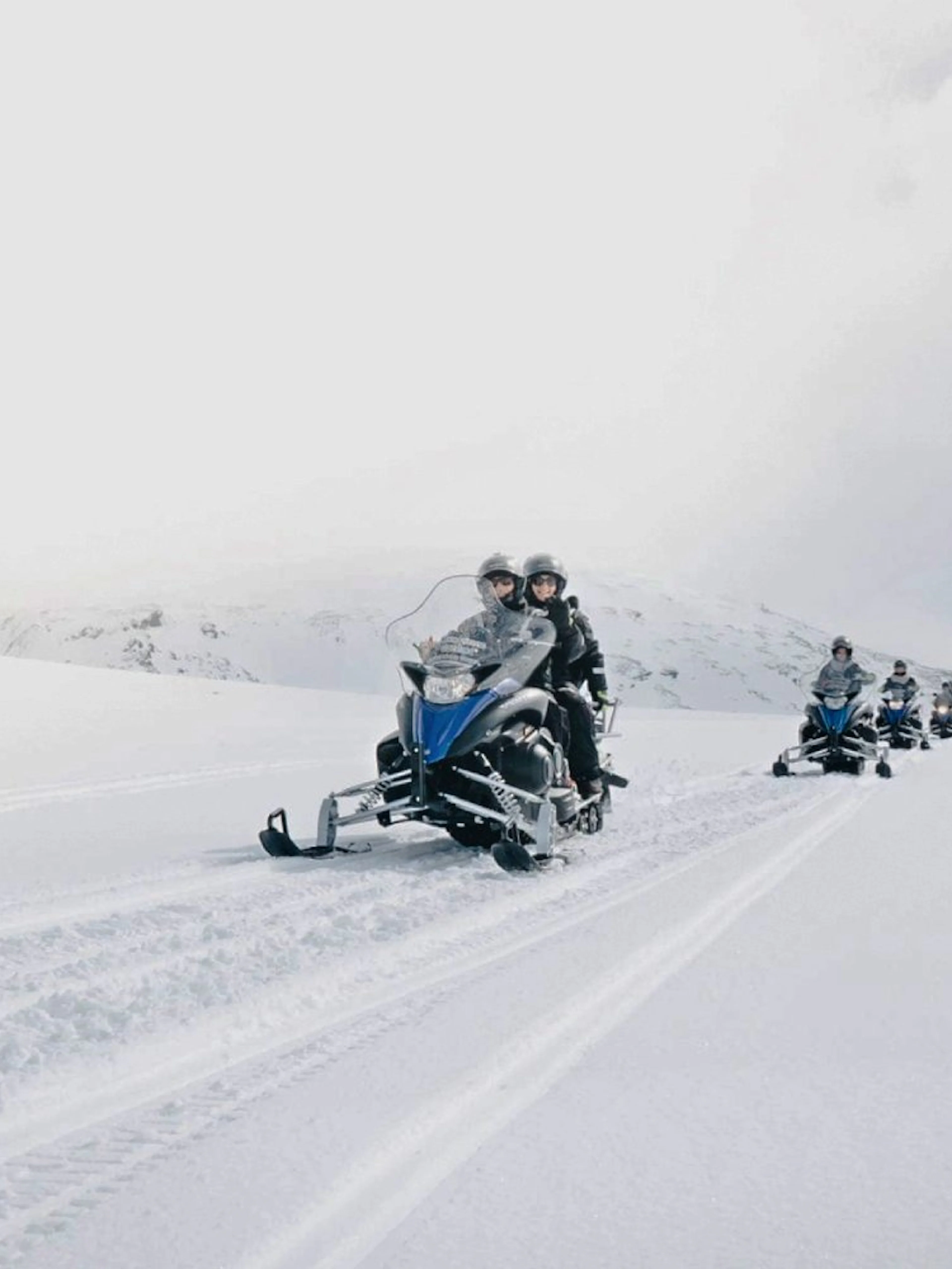 Guests riding snowmobiles on a snowy trail from Gullfoss waterfall in Iceland.