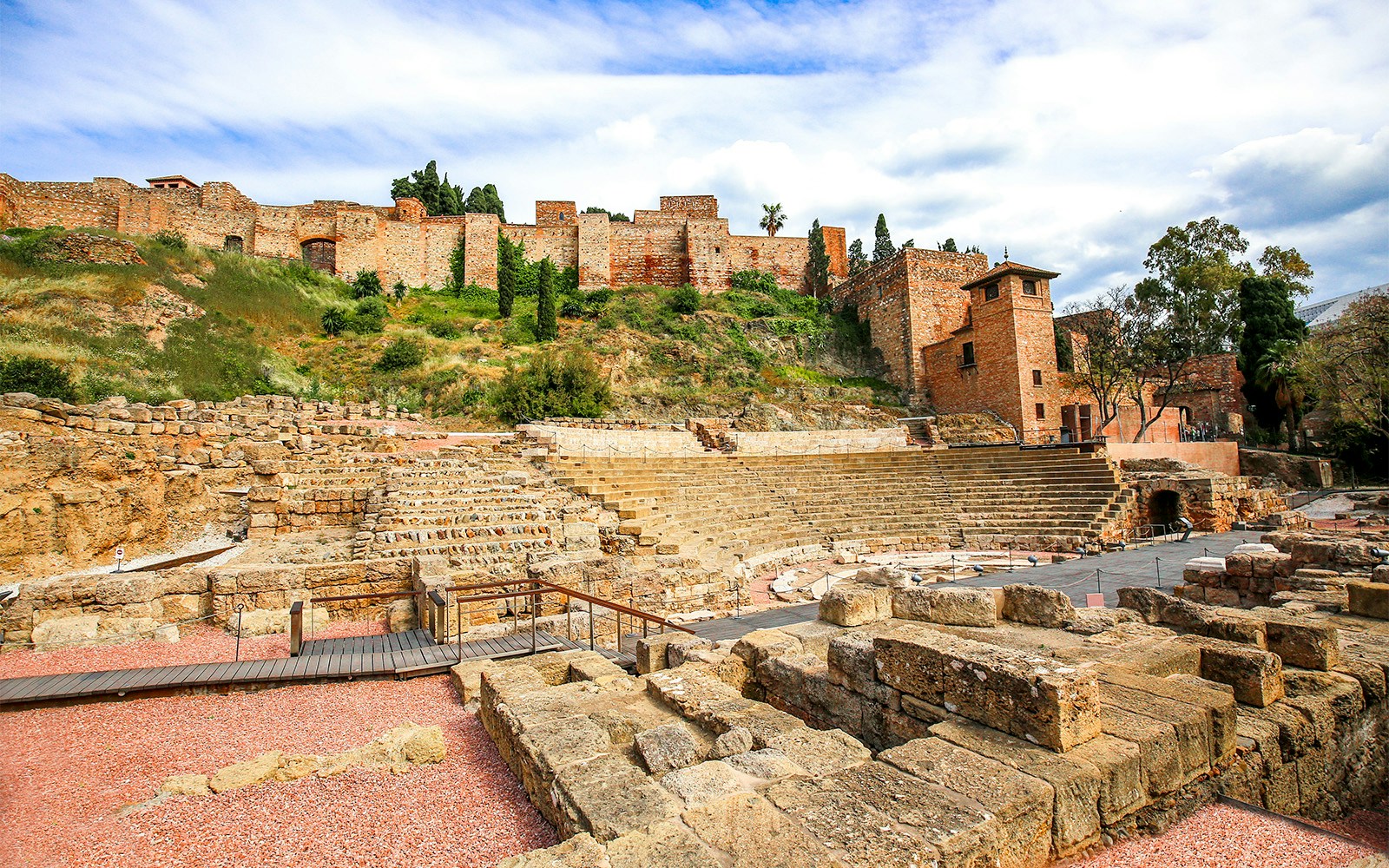 Roman theater ruins with Alcazaba fortress in the background, Malaga, Spain.