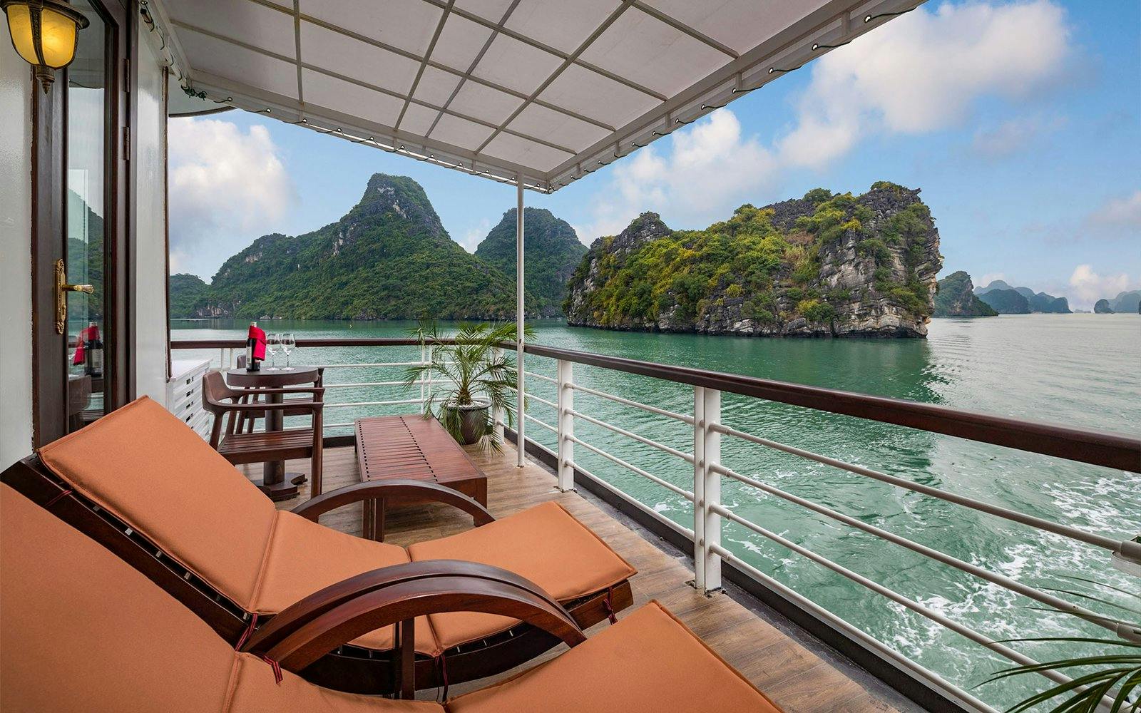 Royal Suite balcony view on Amanda Luxury Cruise with scenic limestone islands.