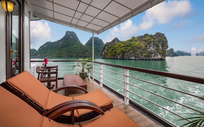 Royal Suite balcony view on Amanda Luxury Cruise with scenic limestone islands.