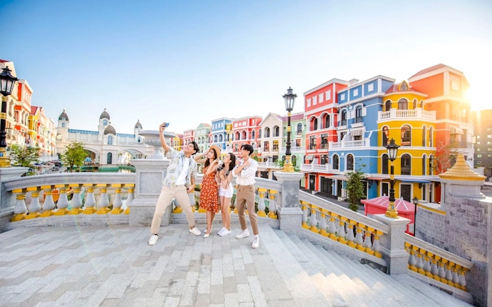 Friends taking a selfie on a colorful street at Grand World Phu Quoc.