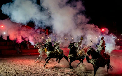 Berber horsemen performing with rifles at Agadir Fantazia night show.