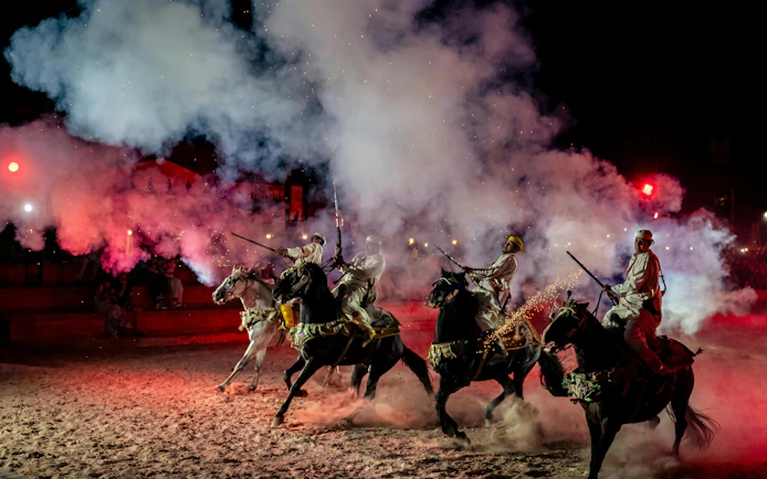 Berber horsemen performing with rifles at Agadir Fantazia night show.