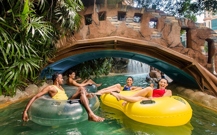 Visitors enjoying a lazy river ride at Sunway Lagoon's water park, Zambezi River attraction.