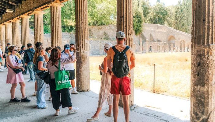 Tour group exploring ancient ruins in Pompeii, Italy.