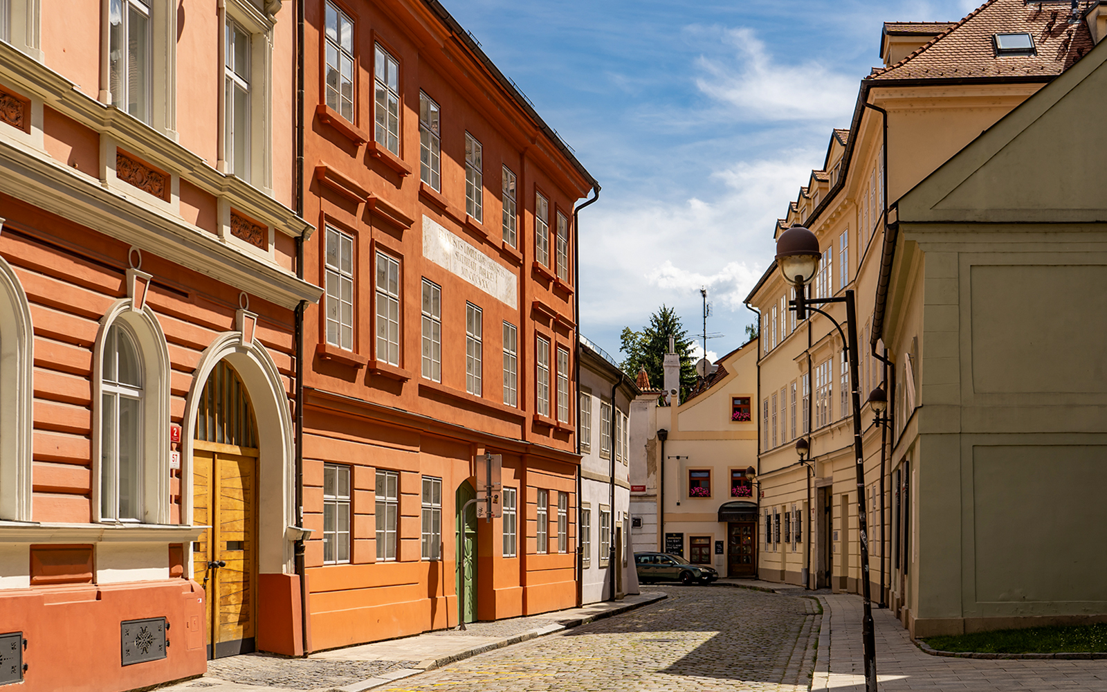 Cobblestone street with colorful historic buildings in Ceske Budejovice, Czech Republic.