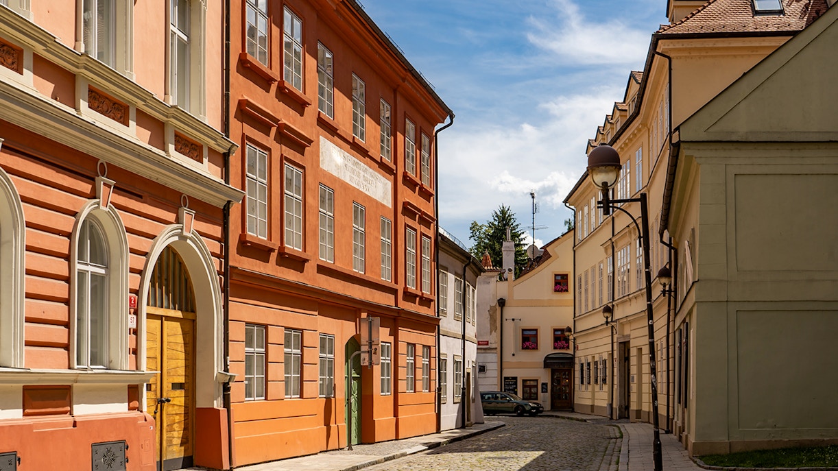 Cobblestone street with colorful historic buildings in Ceske Budejovice, Czech Republic.