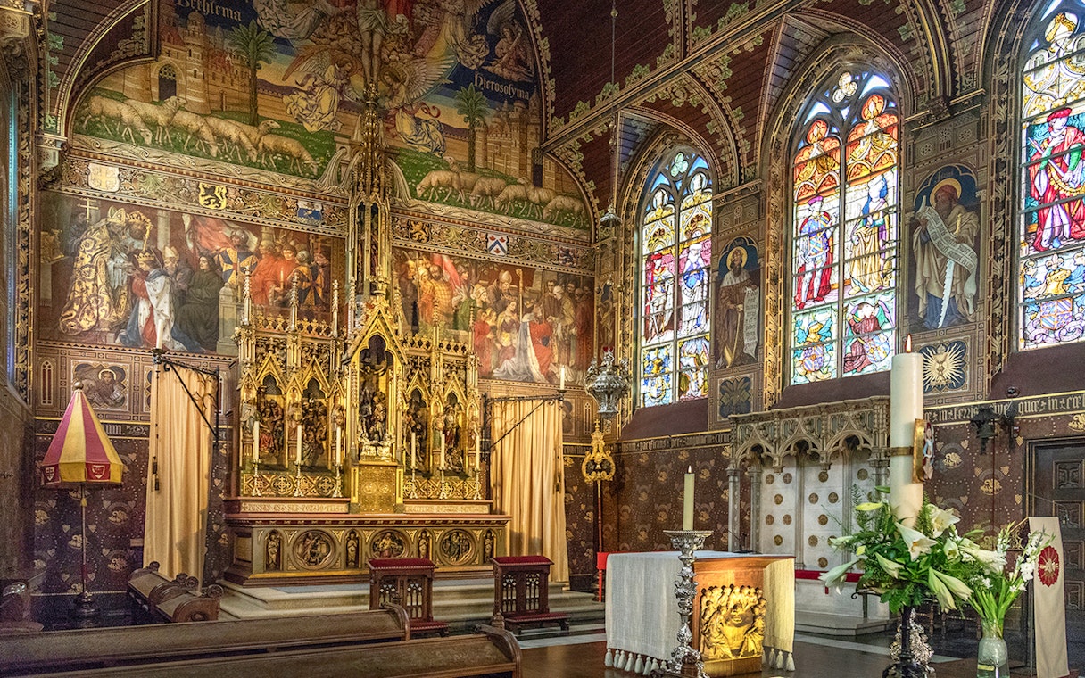 Bruges Basilica of the Holy Blood interior with ornate altar and stained glass windows.