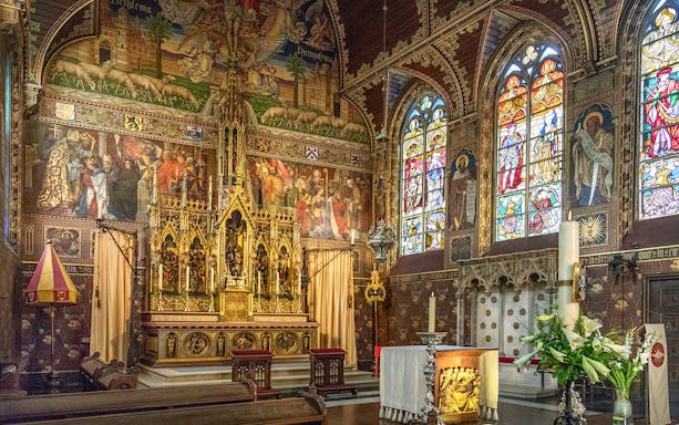 Bruges Basilica of the Holy Blood interior with ornate altar and stained glass windows.