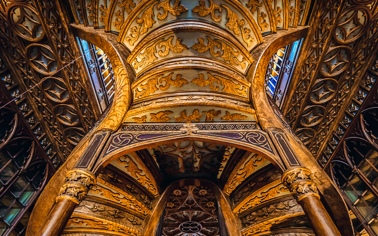 Ornate wooden ceiling and staircase inside Lello Bookstore, Porto, Portugal.