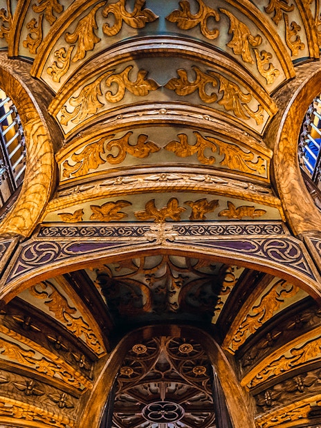 Ornate wooden ceiling and staircase inside Lello Bookstore, Porto, Portugal.