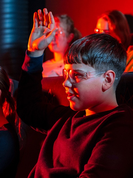 Guests watching the Lava show in Reykjavik, wearing protective glasses.