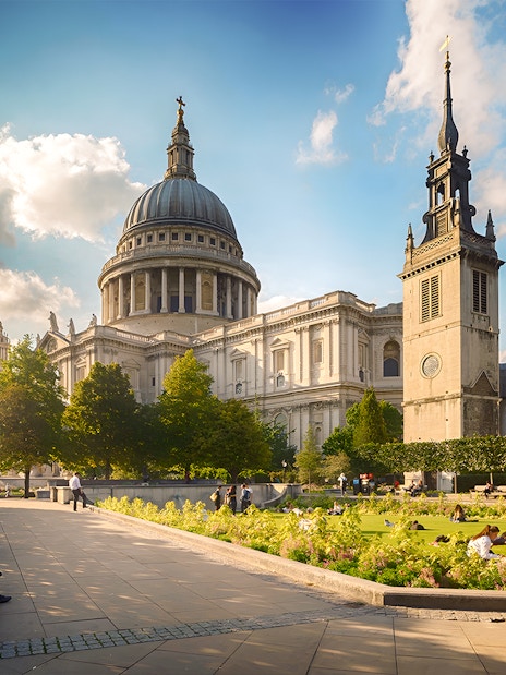 St. Paul's Cathedral in London with people relaxing in the garden.