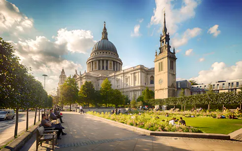 St. Paul's Cathedral in London with people relaxing in the garden.