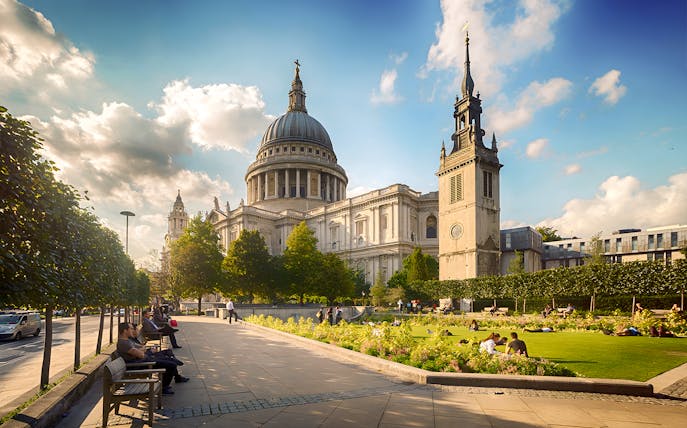 St. Paul's Cathedral in London with people relaxing in the garden.