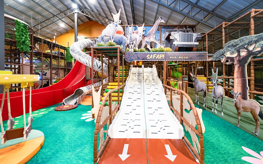 Indoor safari escape playland with slides, animal cutouts, and climbing structures.