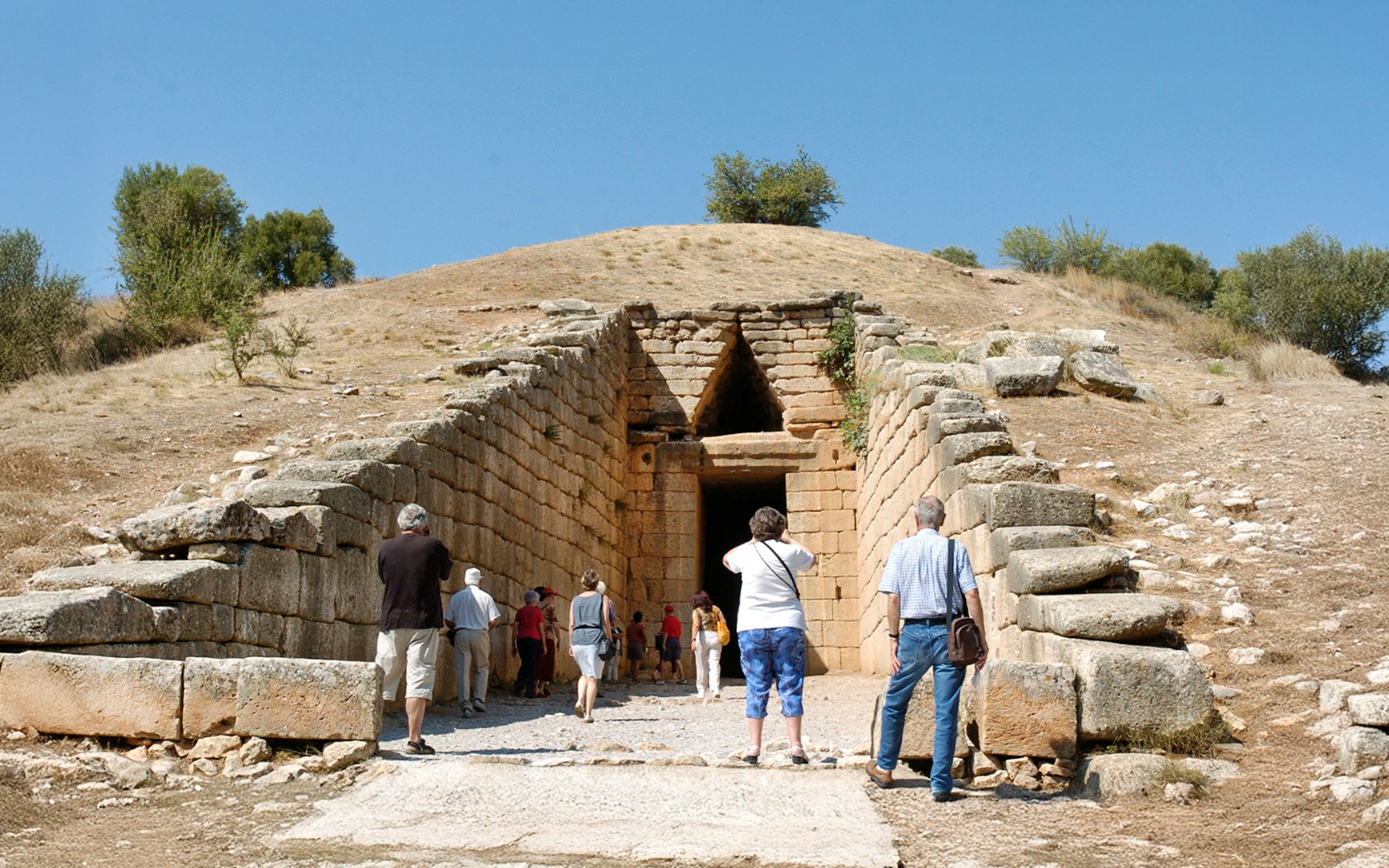 Visitors entering the Tomb of Agamemnon in Mycenae, Greece.