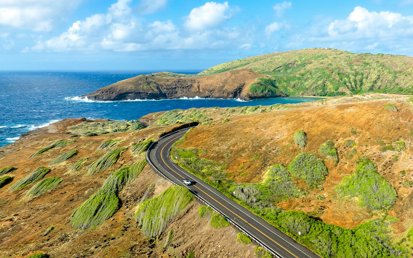 Scenic road near Hanauma Bay with ocean and hills in the background.