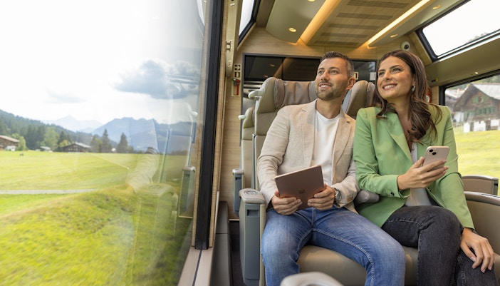A couple enjoying panoramic view in the Prestige Class of Glacier Express