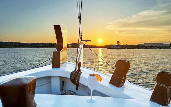 Sunset view from a boat with a cocktail on a Corfu cruise.