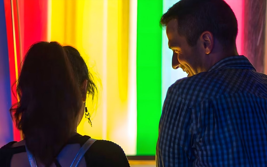 Visitors enjoying colorful light exhibit at the Exploratorium, San Francisco.