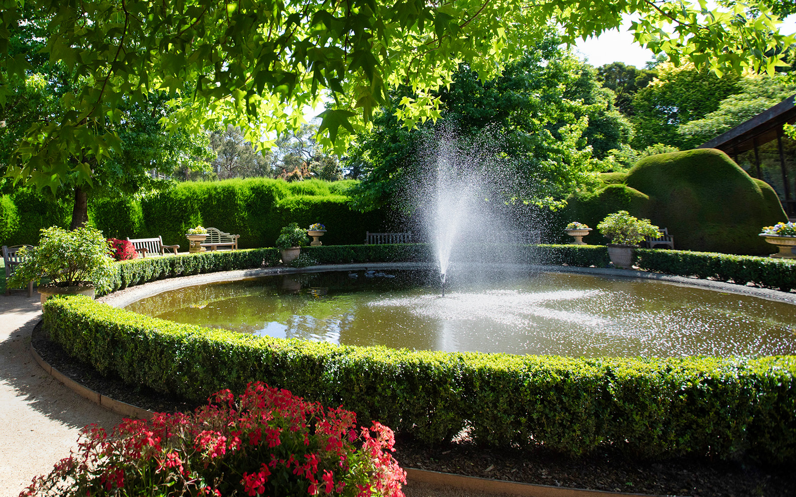 Fountain surrounded by greenery at Aschombe Maze & Lavender Gardens.