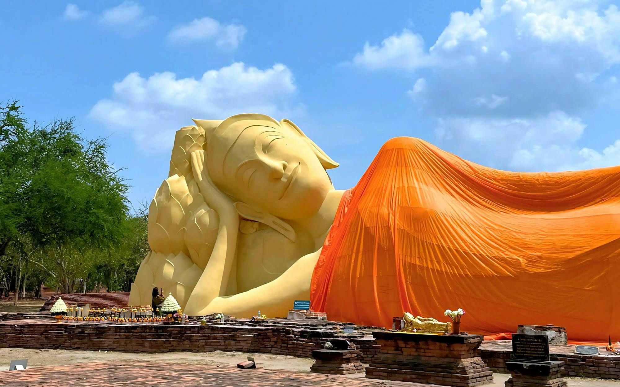 Reclining Buddha statue draped in orange cloth at Ayutthaya Temples, Thailand.