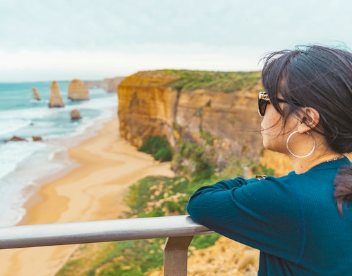 Woman at viewpoint overlooking 12 Apostles along Great Ocean Road, Melbourne