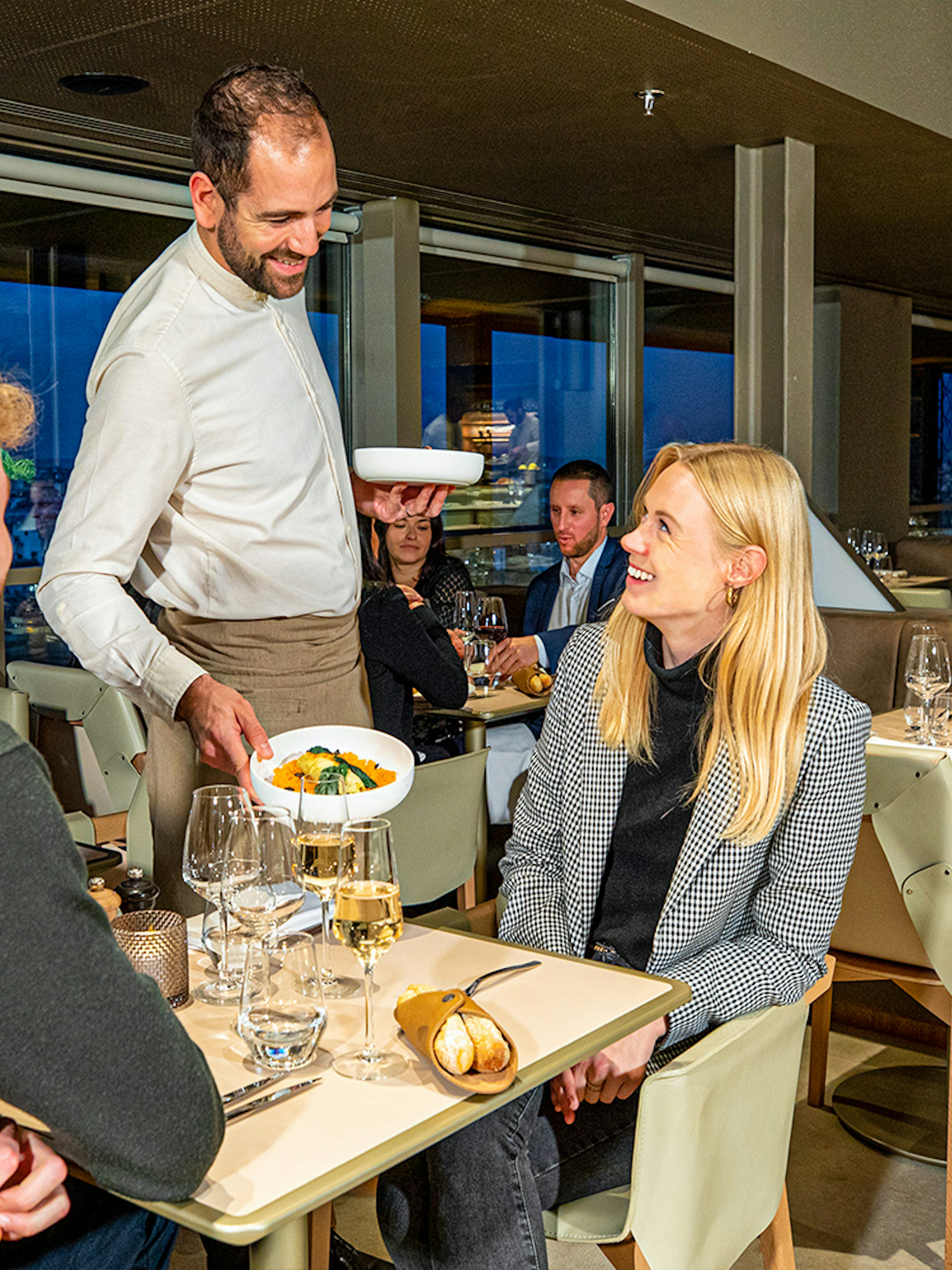 Waiter serving dinner at Madame Brasserie in the Eiffel Tower, Paris.