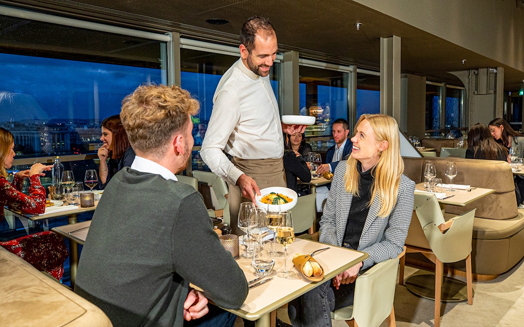 Waiter serving dinner at Madame Brasserie in the Eiffel Tower, Paris.