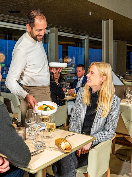 Waiter serving dinner at Madame Brasserie in the Eiffel Tower, Paris.