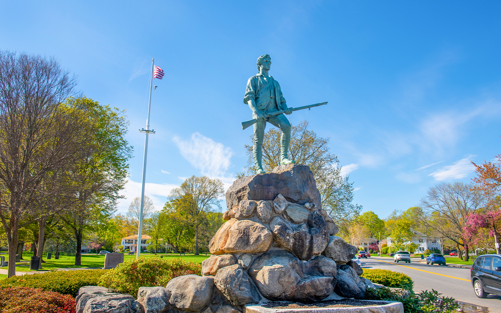 Minute Man Statue on Battle Green, Lexington, Massachusetts, with American flag in background.