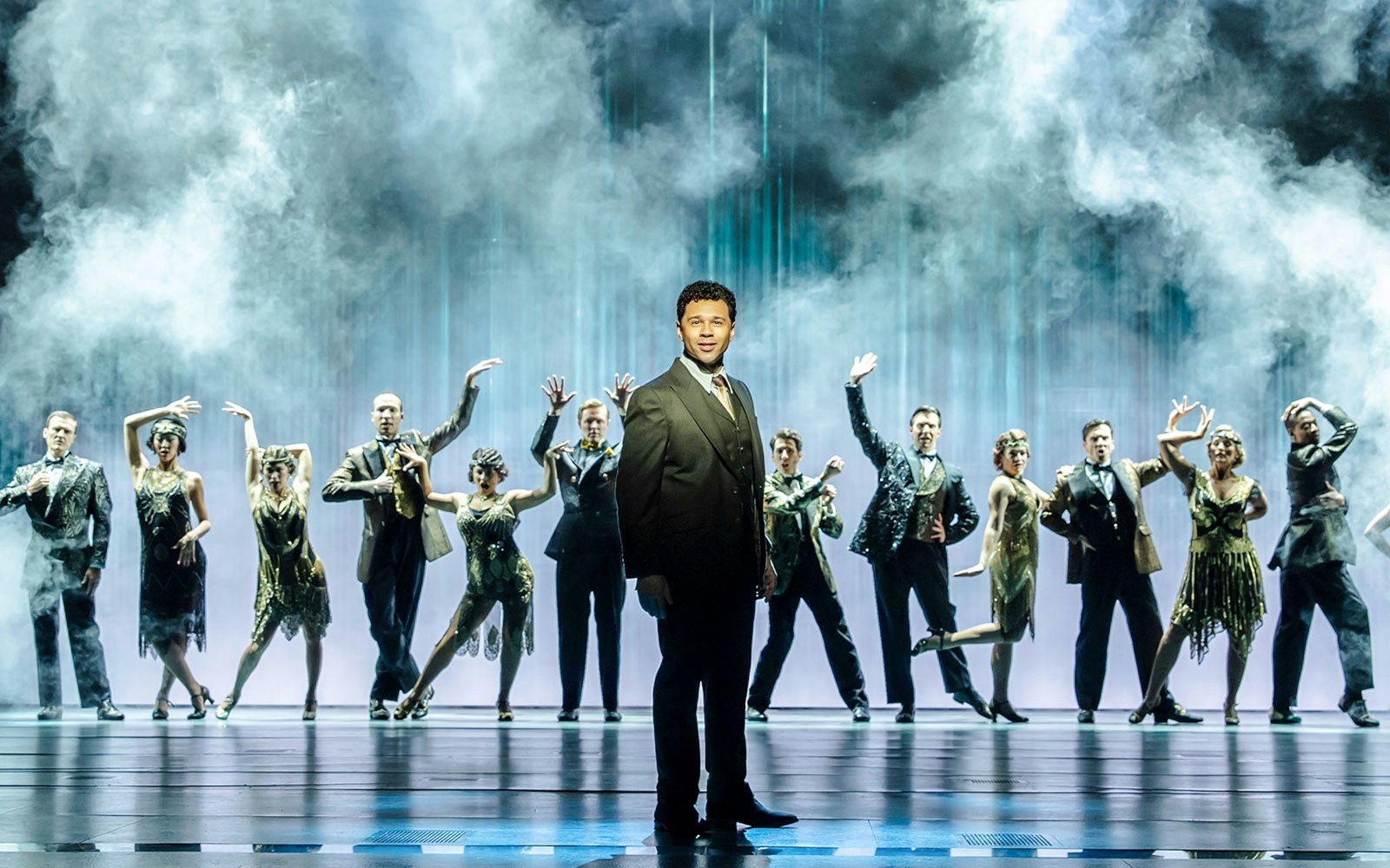 Cast performing on stage in The Great Gatsby Musical with a smoky backdrop.