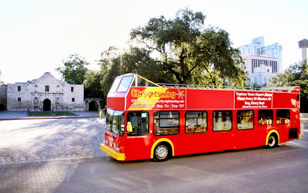 Red double-decker bus in front of the Alamo, San Antonio Hop-On-Hop-Off Tour.