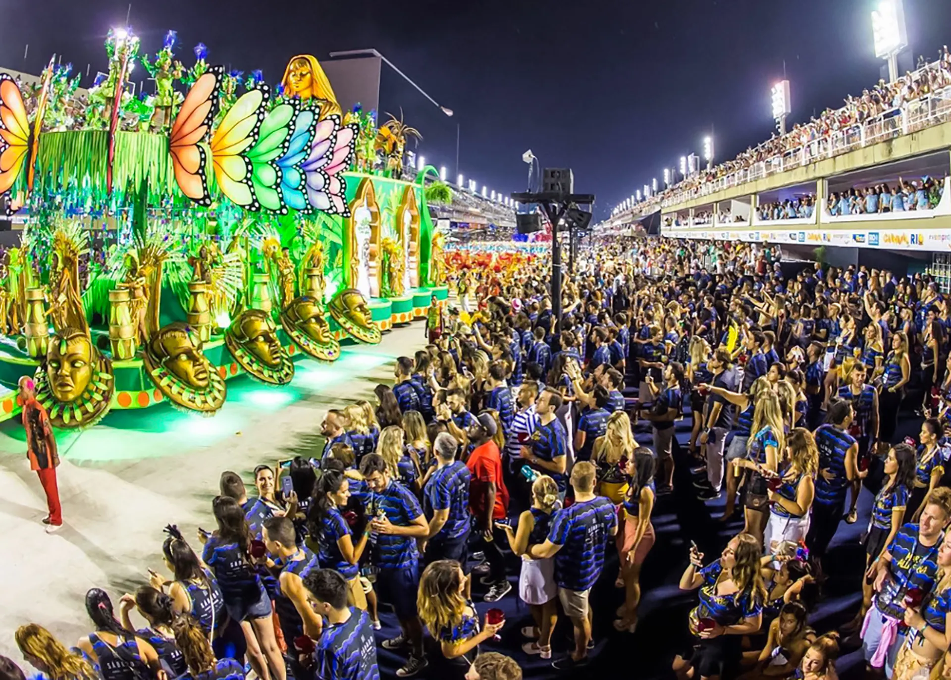 Crowd enjoying vibrant parade floats at Rio Carnival 2027, Marquês de Sapucaí, Rio de Janeiro.