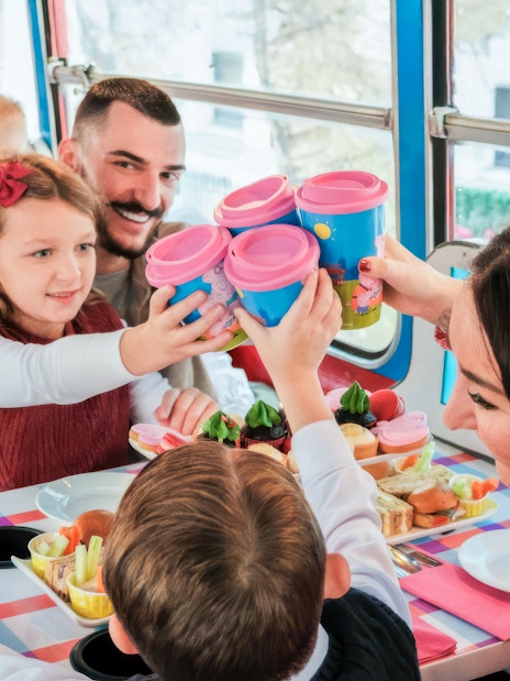 Kids and parents enjoying snacks on Peppa Pig themed bus tour.