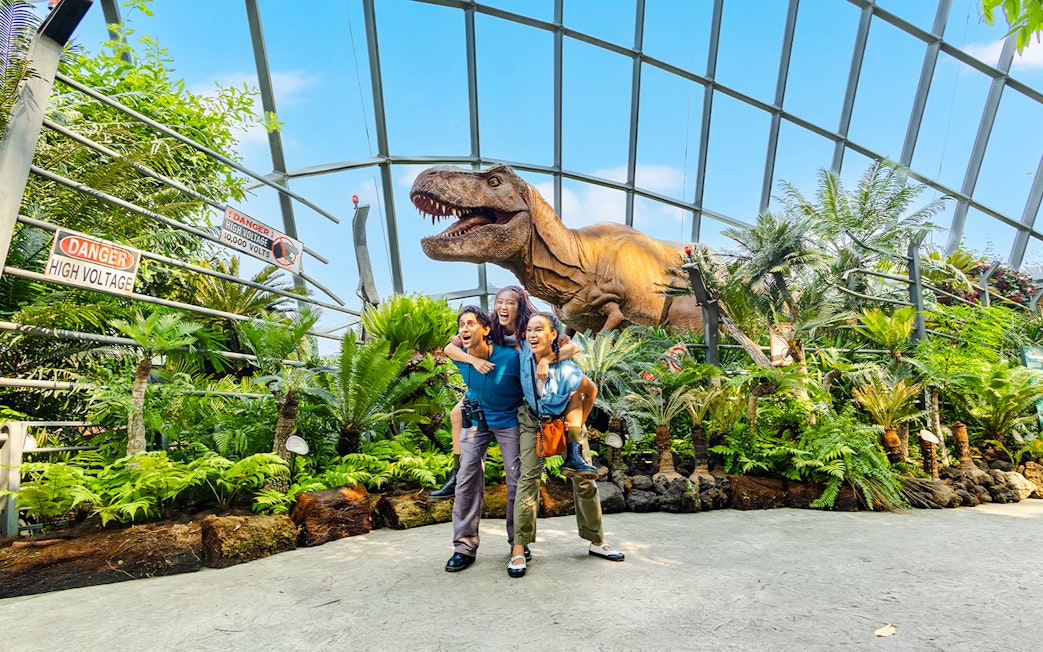 Visitors at Jurassic World exhibit, Cloud Forest, Gardens by the Bay, Singapore with dinosaur model.