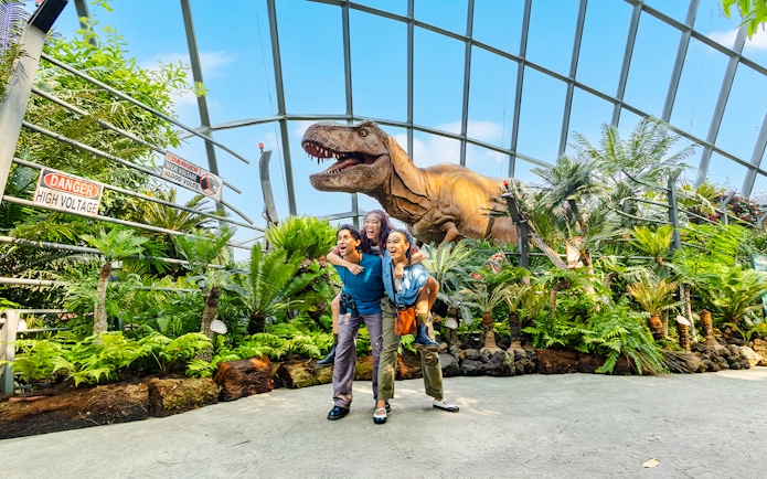 Visitors at Jurassic World exhibit, Cloud Forest, Gardens by the Bay, Singapore with dinosaur model.
