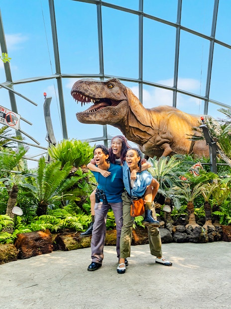Visitors at Jurassic World exhibit, Cloud Forest, Gardens by the Bay, Singapore with dinosaur model.