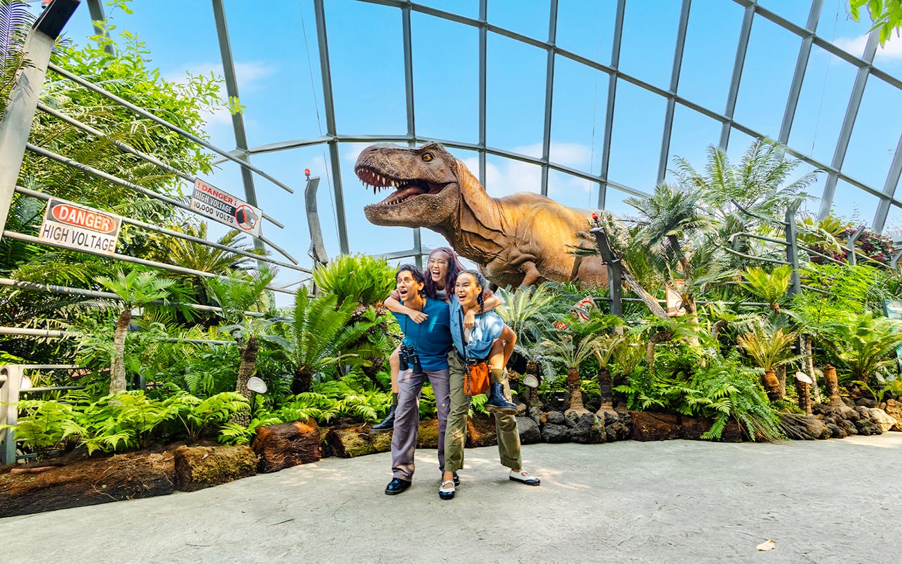Visitors at Jurassic World exhibit, Cloud Forest, Gardens by the Bay, Singapore with dinosaur model.