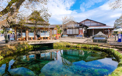 Owaike Pond in Oshino Hakkai Village, Japan, with traditional buildings and clear water.