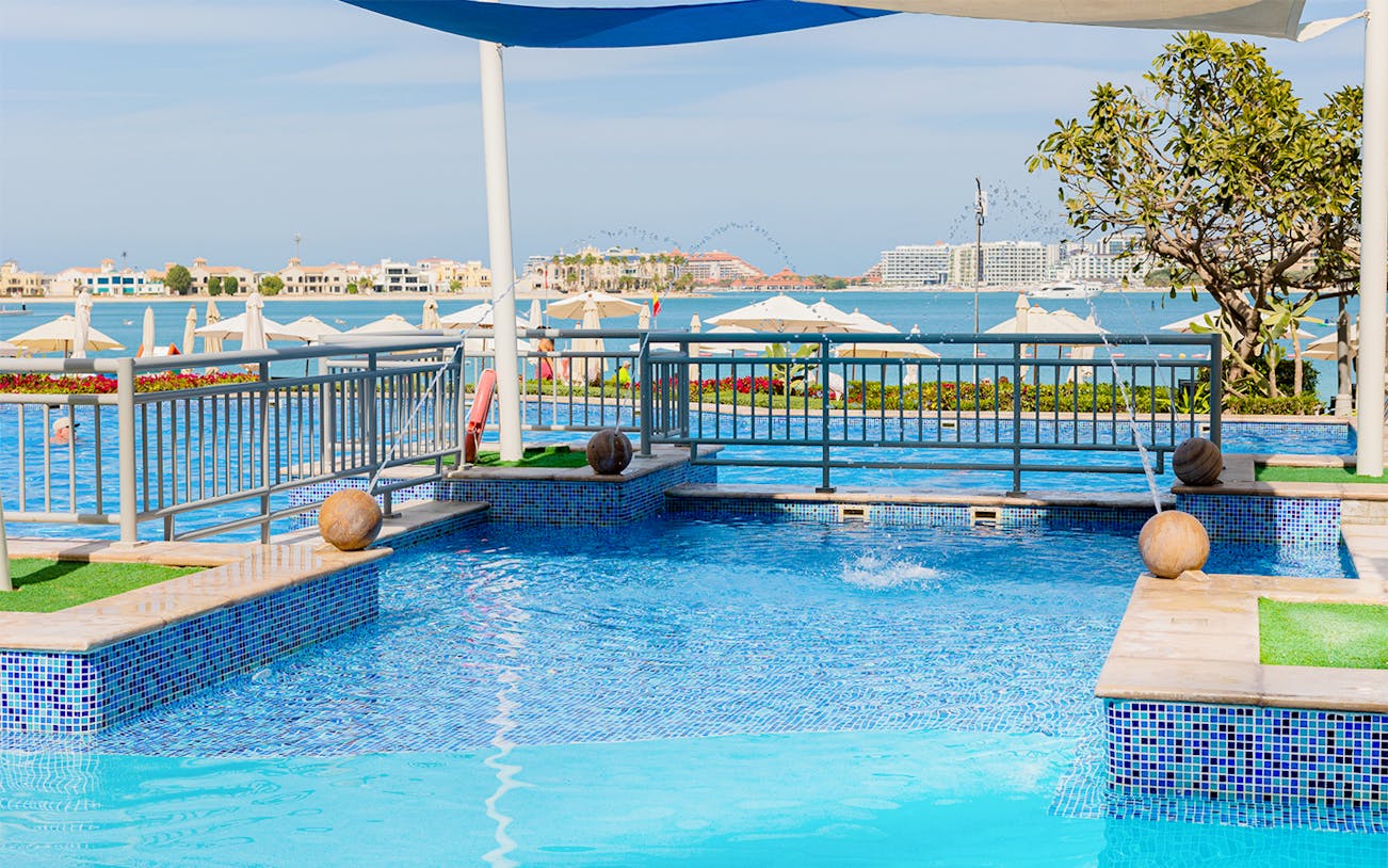 Riva Beach Club pool with ocean view and sun loungers in Dubai.