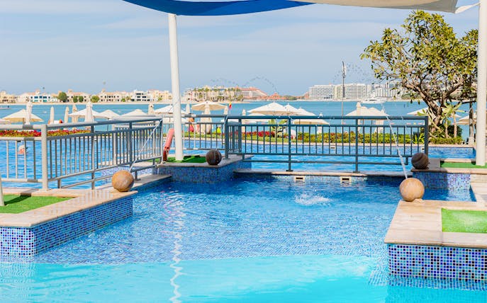 Riva Beach Club pool with ocean view and sun loungers in Dubai.