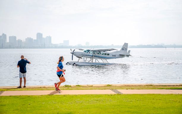 Seaplane on Swan River with Perth skyline in the background.